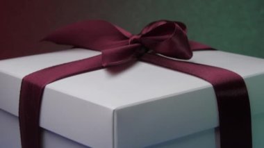 Renkli parlayan ışıkların altında kurdeleli Noel kutusu