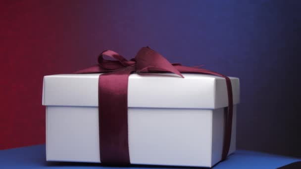 Scatola di cartone regalo bianco con nastro viola e fiocco — Video Stock