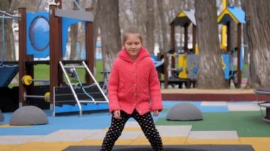 Komik liseli kız trambolinde zıplar ve neşeyle gülümser.