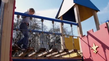 Uzun örgülü genç kız mavi köprü boyunca yürüyor.