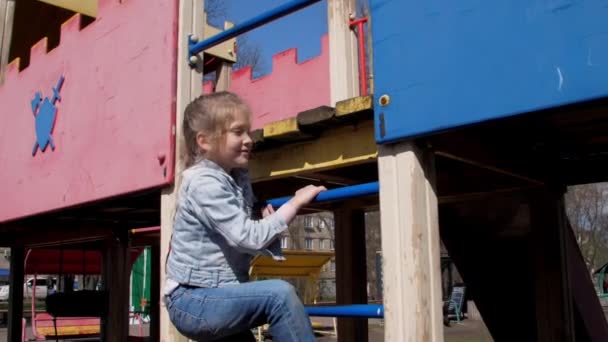 Ung skolflicka med vackert hår i flätor klättrar uppför stegen — Stockvideo