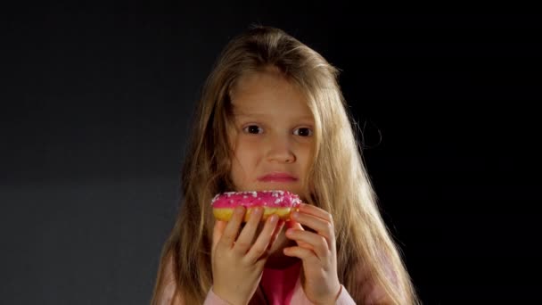 Largo pelo suelto rubia junior colegiala muerde donut — Vídeo de stock