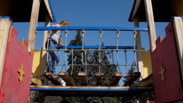 Careful blonde schoolgirl walks along castle playground — Stock Video