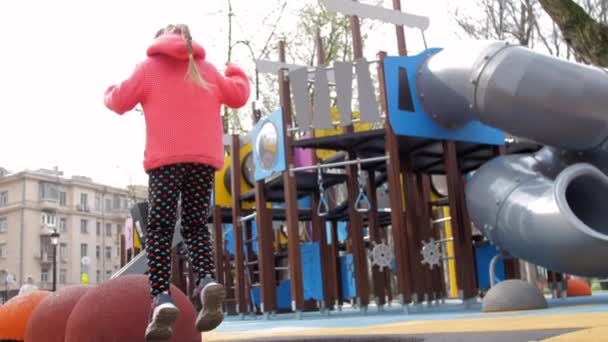 Genç bayan trambolinde atlar ve taş desteğinde durur. — Stok video