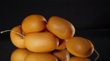 İplikli kahverengi sosisler cama yansıyan masaya uzanıyorlar.