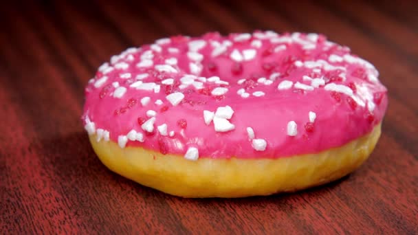 Köstlicher Donut mit rosa Fondant bestreut mit weißem Zucker — Stockvideo