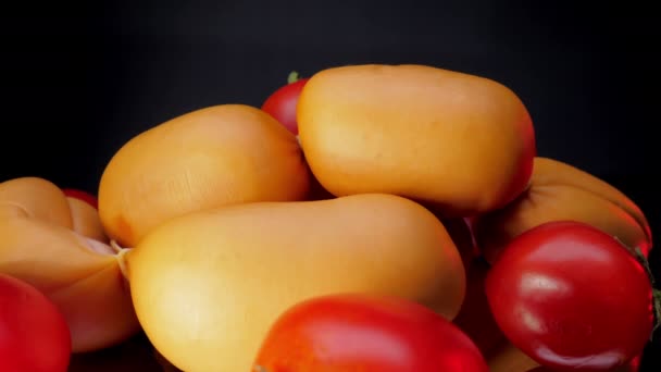 Los tomates cherry y los pandilleros marrones yacen sobre una mesa de vidrio negro — Vídeo de stock