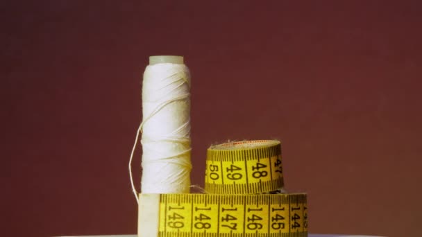 白い糸が回転する黄色の測定テープとスプール — ストック動画
