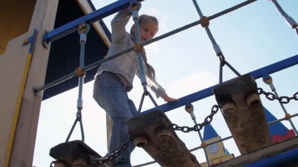 Niña en vaqueros vaqueros y chaqueta camina de nuevo la luz del sol — Vídeos de Stock