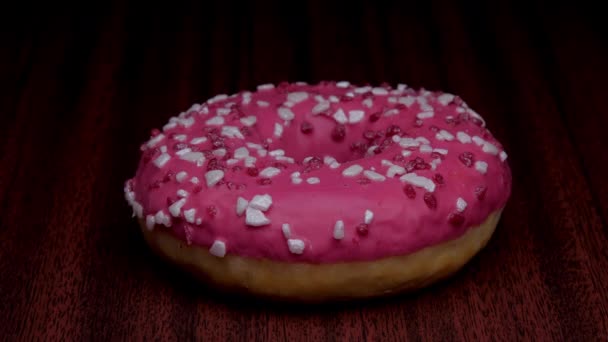 Rosado y marrón donut espolvoreado con elementos de color — Vídeos de Stock