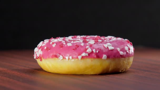 Rosquilla fresca con crema rosada gira bajo luz eléctrica — Vídeos de Stock