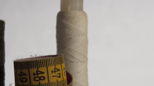 Carretéis com fios brancos e castanhos por fita métrica amarela — Vídeo de Stock