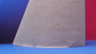 Gri tuvalet kağıdı duvara karşı mavi destekle dönüyor