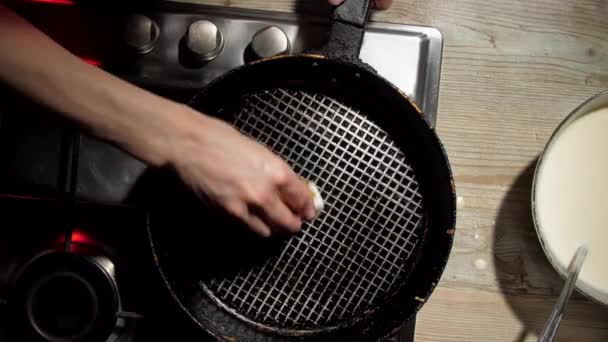 Домохозяйка вытирает черную сковородку с белым жиром — стоковое видео