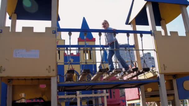 Vorsichtiges blondes Schulmädchen spaziert über Burgspielplatz — Stockvideo