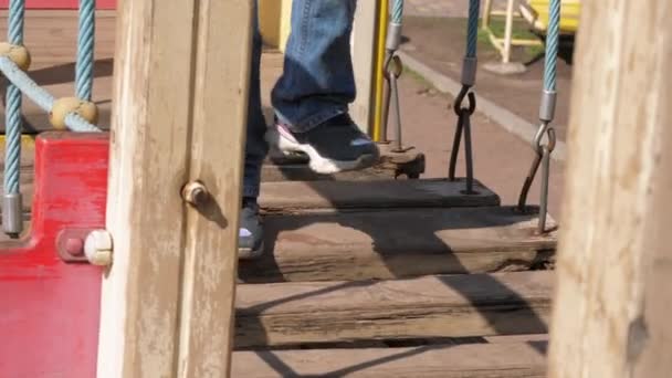 Menina pequena em jeans jeans jeans e jaqueta caminha para trás luz solar — Vídeo de Stock