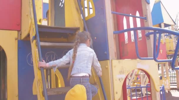 Junior écolière en pull grimpe attraction en métal — Video