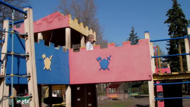 Estudante loira cuidadosa caminha ao longo do parque infantil do castelo — Vídeo de Stock