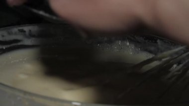 Yetenekli aşçı beyaz krep hamuruyla un toplar.