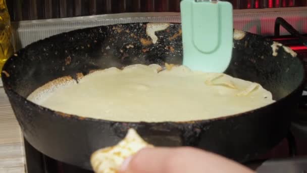 Νοικοκυρά γυρίζει γύρω τηγανίτα με ειδική σπάτουλα — Αρχείο Βίντεο
