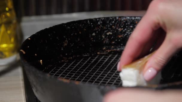 Νοικοκυρά σκουπίζει μαύρο τηγάνι με λευκή φέτα λίπους — Αρχείο Βίντεο