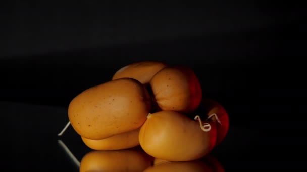 Deliciosas salchichas crudas se encuentran en la mesa de vidrio negro girando — Vídeos de Stock