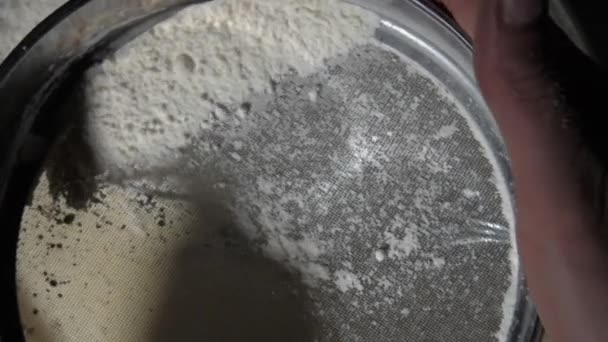 Seseorang menyaring tepung dalam sifter logam di atas adonan di restoran — Stok Video