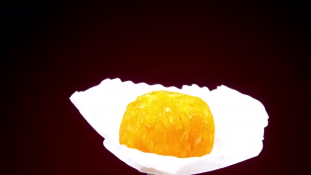 Delicioso caramelo dulce de color amarillo sobre papel blanco — Vídeo de stock
