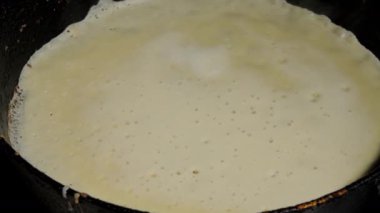 Siyah tavada hamurlu sarı beyaz krep.