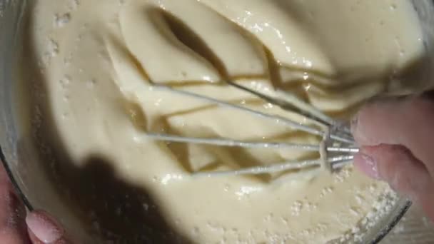 Tangan masak profesional memegang whisk logam dan adonan campuran — Stok Video