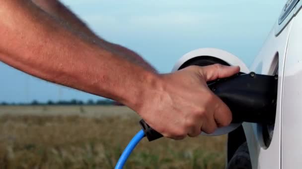 Elektrische auto opgeladen door windturbine man neemt stekker uit ev — Stockvideo