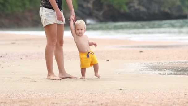 Barn går i handtag med mamma på stranden — Stockvideo