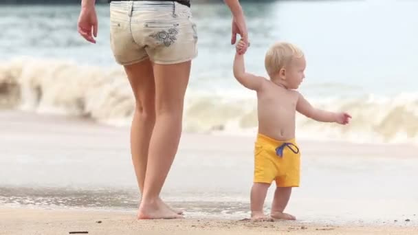 Criança caminha pelo punho com a mãe na praia — Vídeo de Stock