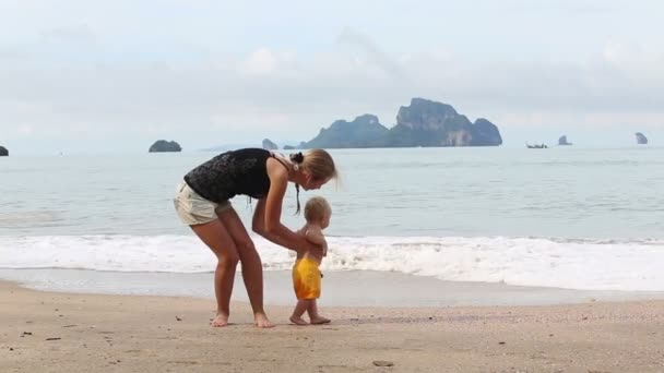 Дитина з матір'ю на пляжі — стокове відео