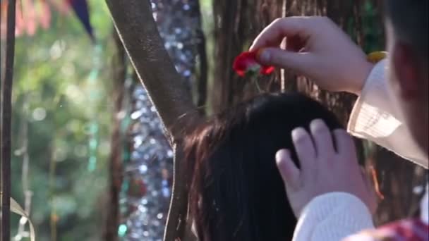 Наречений кладе квітку в волосся нареченої — стокове відео