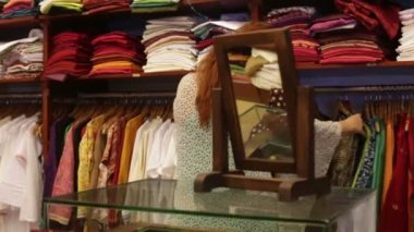 vrouw kiest kleren in een winkel