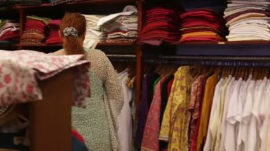 vrouw kiest kleren in een winkel