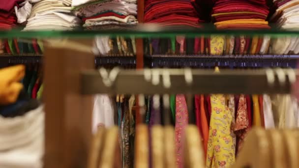 Mujer elige ropa en una tienda — Vídeo de stock