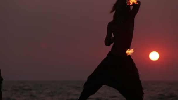Мужчина-артист крутит огненный пои на камне — стоковое видео