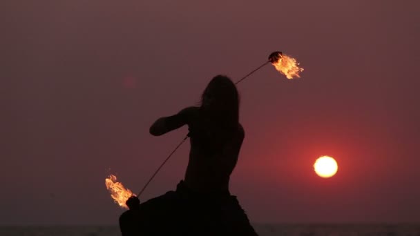 Male Artist of the spins fire poi on a rock — Stock Video