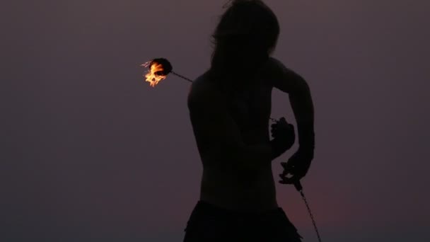 Male Artist of the spins fire poi on a rock — Stock Video