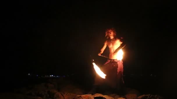 Male Artist of the spins fire poi on rock — Stock Video