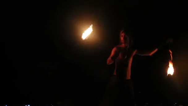Male Artist of the spins fire poi on rock — Stock Video