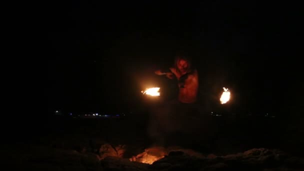 Male Artist of the spins fire poi on rock — Stock Video