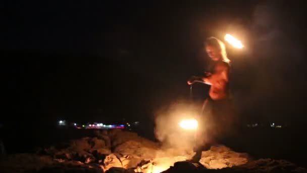 Male Artist of the spins fire poi on a rock — Stock Video