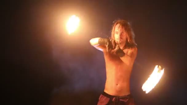 Male Artist of the spins fire poi on a rock — Stock Video