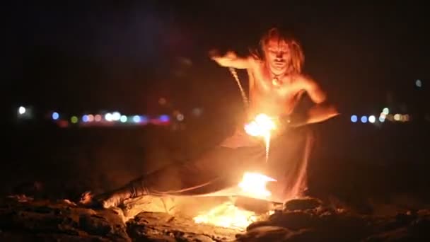 Male Artist of the spins fire poi on a rock — Stock Video