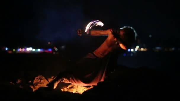 Αρσενικός καλλιτέχνης των περιστροφών αλυσίδες πάνω σε ένα βράχο με φωτιά — Αρχείο Βίντεο