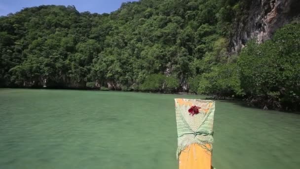 Petit bateau naviguant dans la lagune entre les rochers — Video