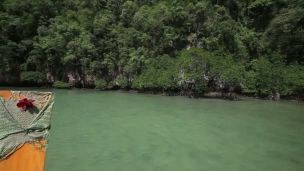 Маленькая лодка, плавающая в лагуне среди скал — стоковое видео